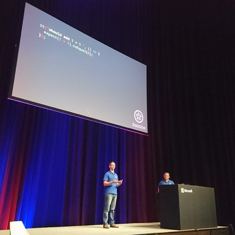 Duncan and Adam Stephensen on the Microsoft Ignite stage with a Jasmine test on the slide.