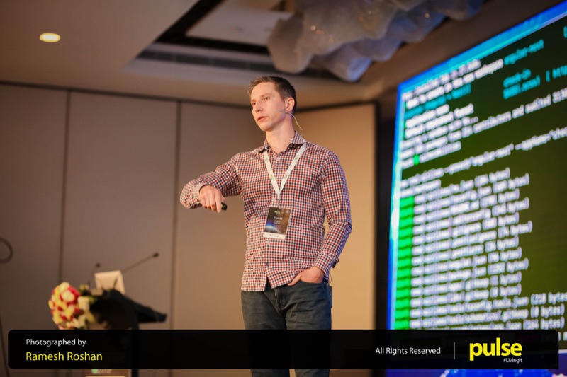 Duncan on a large ballroom stage with a headset mic, terminal output on the big screen.
